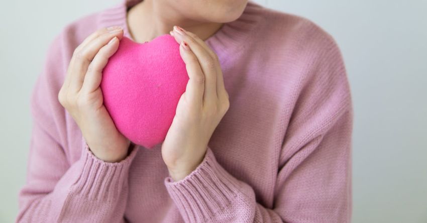 Medicine Ball Exercises - Crop woman with pink heart in hands.