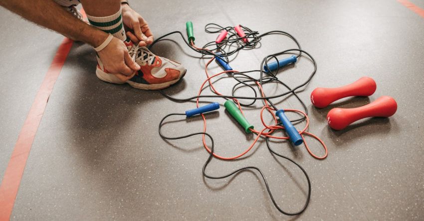 Jump Ropes - A Man Tying his Shoe Lace Beside Jump Ropes on the Floor