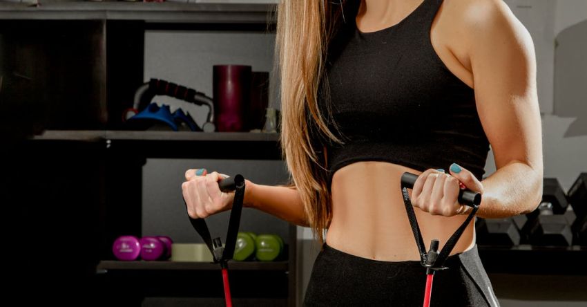 Resistance Bands - Woman Wearing a Sports Bra Exercising