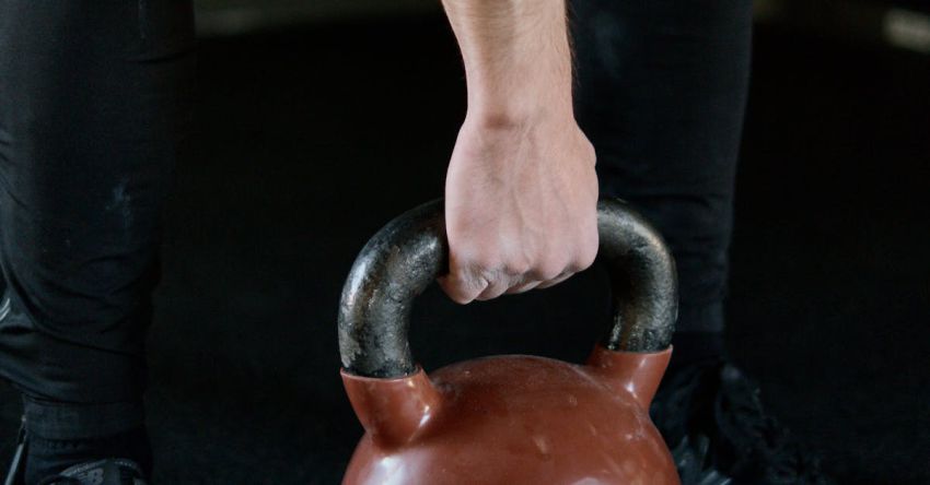 Kettlebell Exercises - Person in Black Pants Holding Red Kettlebell