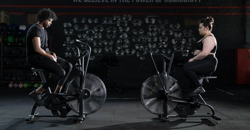 Exercise Bike - Man and Woman Exercising Using a Stationary Bicycle