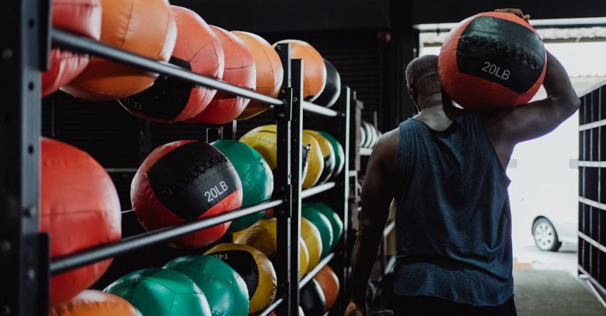 Medicine Balls - Man in Tank Top Carrying a Medicine Ball